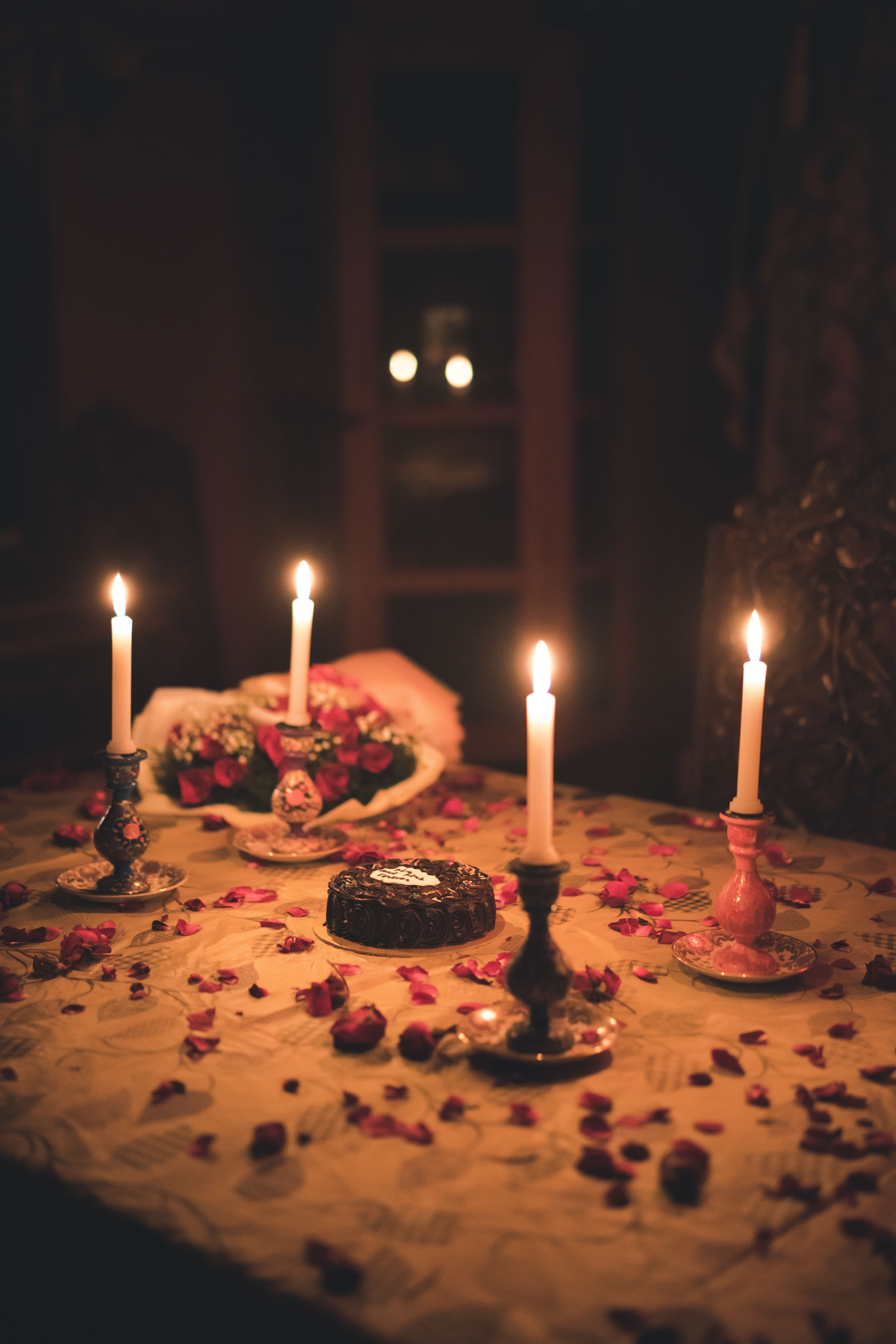 Romantic anniversary table with burgundy roses, wine and candlelight