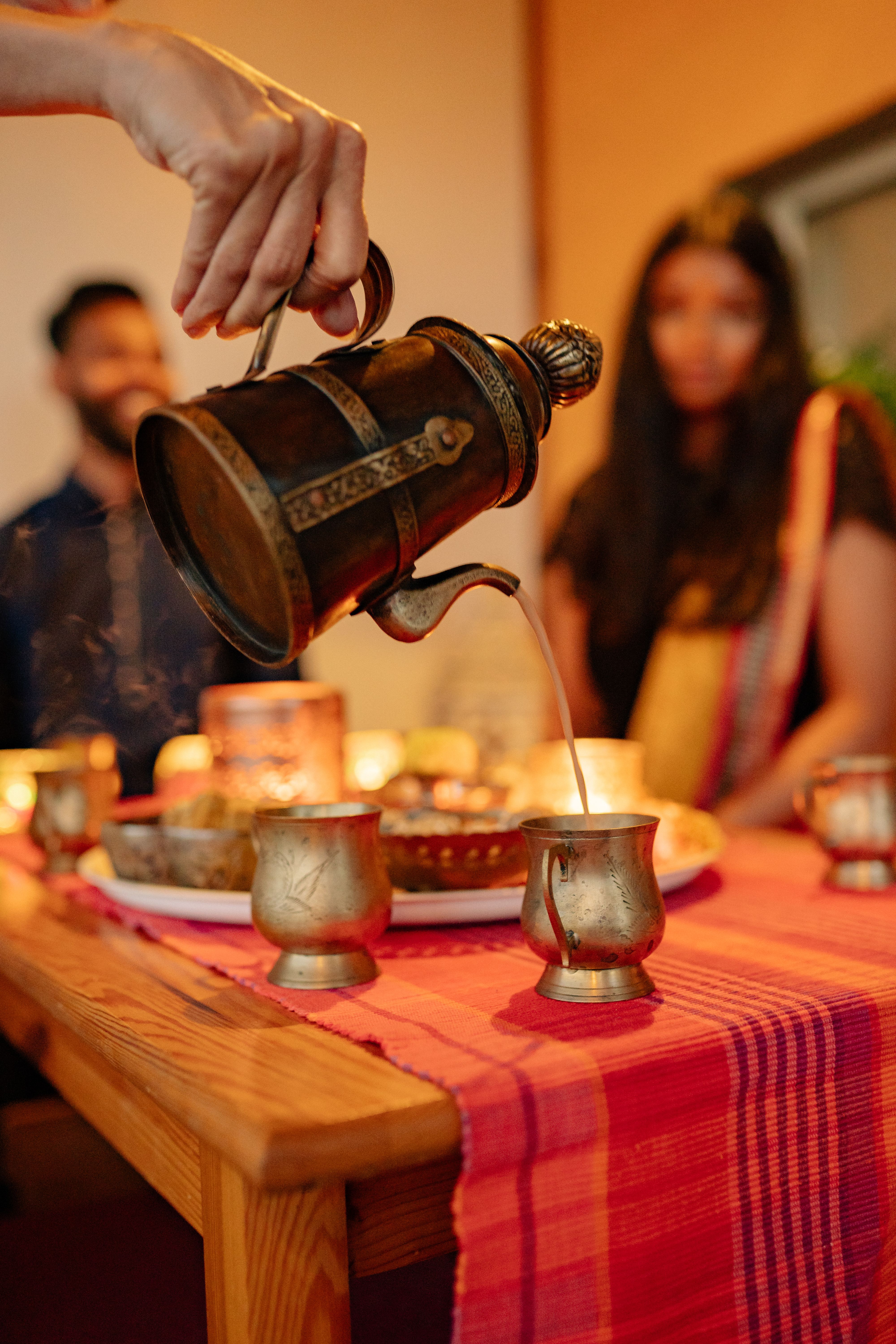 Friends toasting chai and cocktails at Indian housewarming