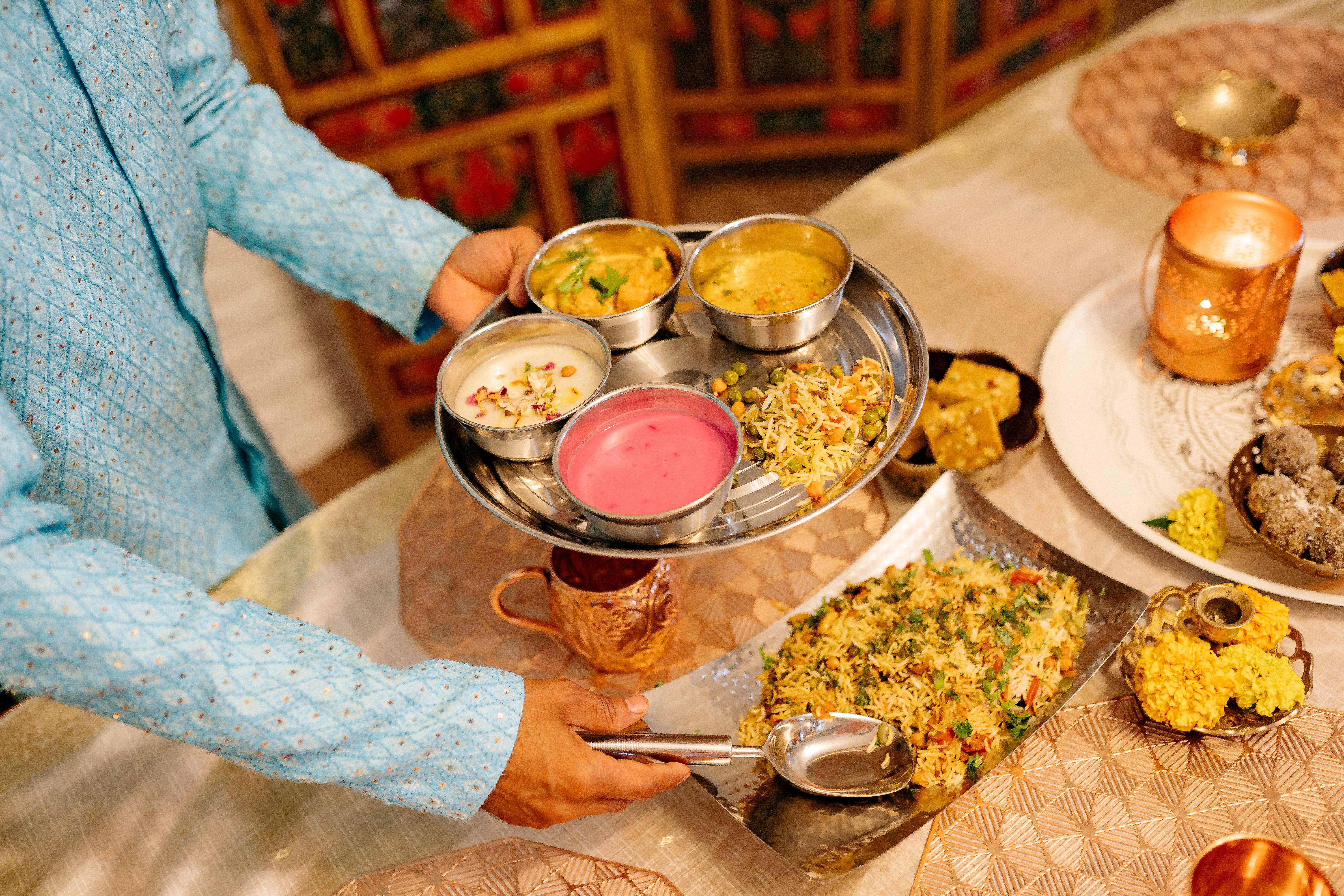 Brass thali overflowing with Indian sweets